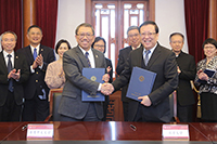Professor Rocky Tuan (left) of CUHK signs collaboration agreements with Professor Hao Ping of PKU